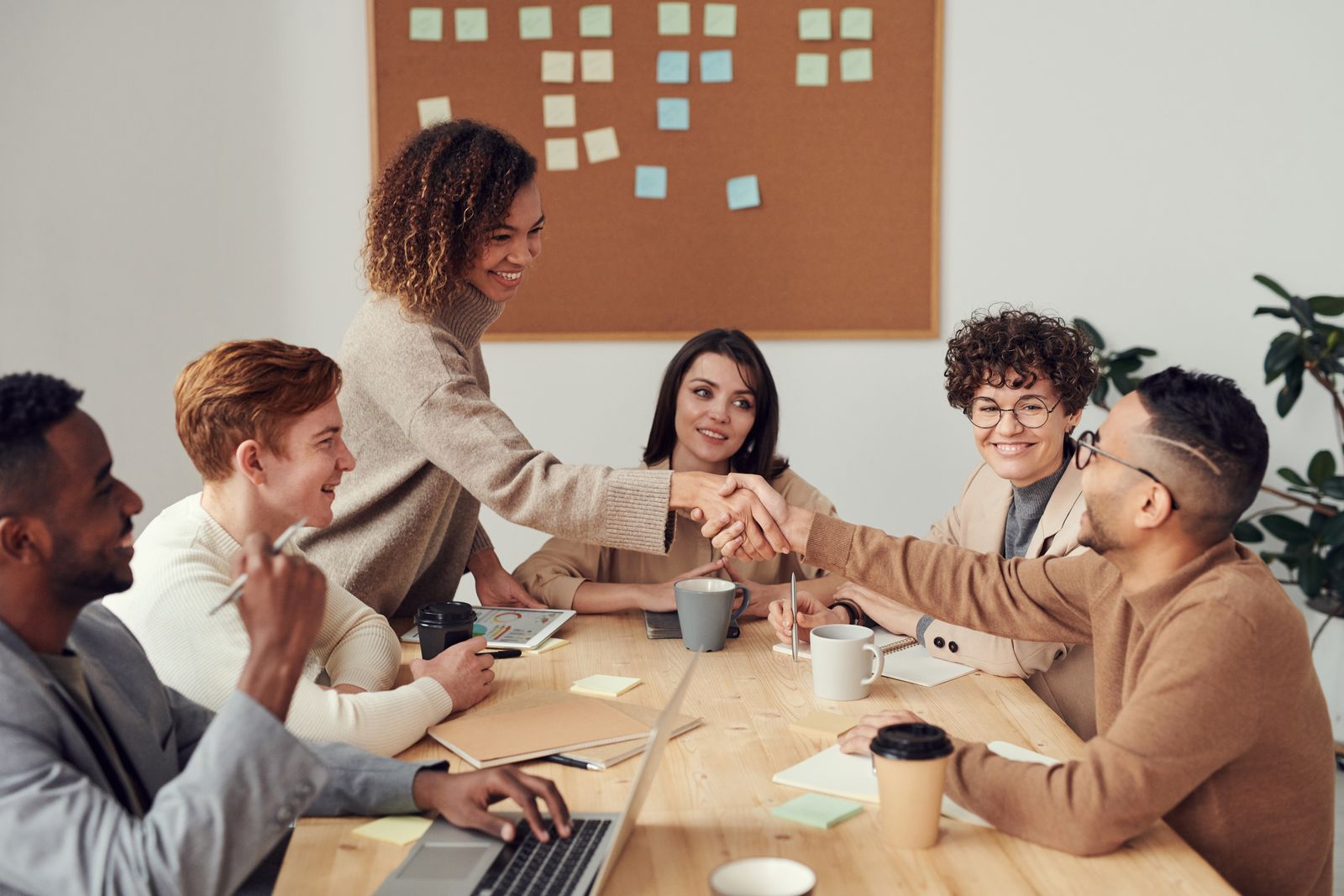 Dois profissionais se cumprimentando com um aperto de mãos em ambiente corporativo